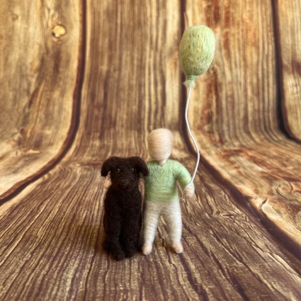 Kleine Filzfigur mit grünem Pullover, Ballon und Hund an der Seite – handgefertigt